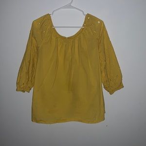 This very unique top is a beautiful yellow with small cut outs in the sleeve.